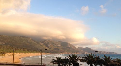 Scenic view of sea and mountains against sky