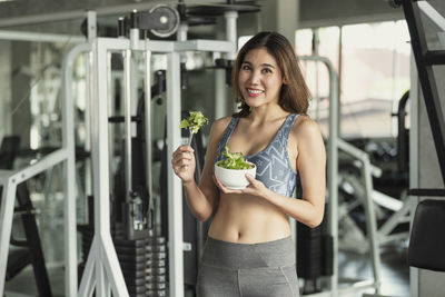 Portrait of a smiling young woman holding food