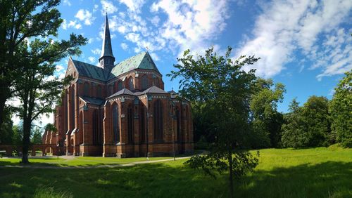 Traditional building by trees against sky