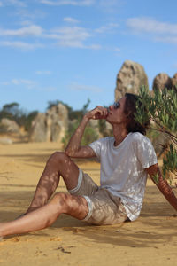 Young man resting on the shadow of the desert