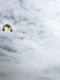 Low angle view of parachute against cloudy sky