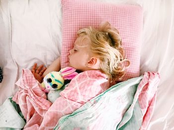 Directly above shot of girl sleeping on bed