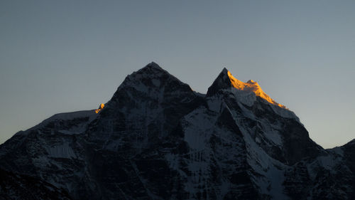 Low angle view of snowcapped mountain against sky during sunset