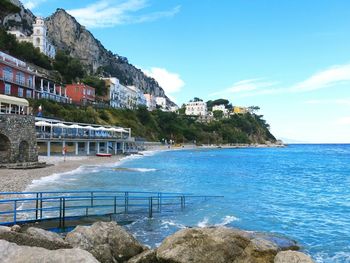 Scenic view of sea by buildings against sky