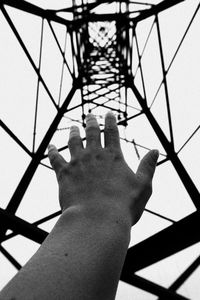 Low angle view of person hand holding metal structure