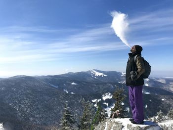 Man standing on mountain against sky