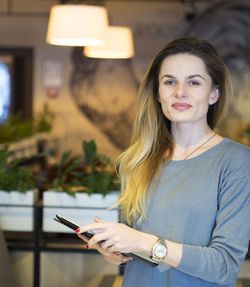 Portrait of smiling young woman using mobile phone