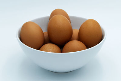 Close-up of eggs in bowl against white background