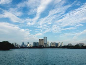 Sea by cityscape against sky