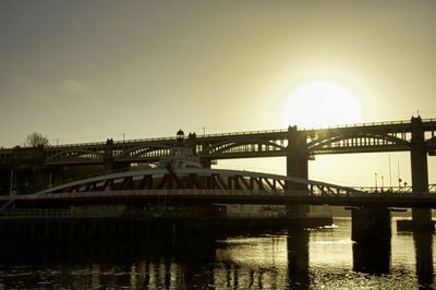 Bridge over river against sky during sunset