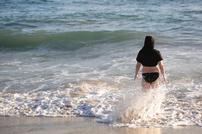 Rear view of man surfing in sea