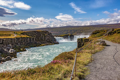 Scenic view of waterfall against sky