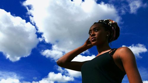 Low angle view of woman looking away against sky