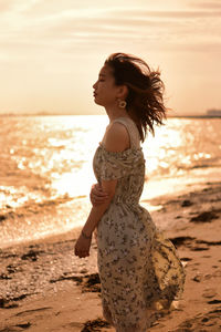 Side view of woman standing at beach