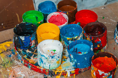 Jars of the artist with bright colors in the art workshop