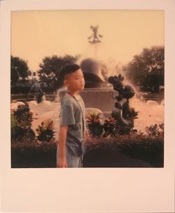 Girl standing by palm tree against sky