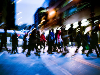 Blurred motion of people walking on road at night