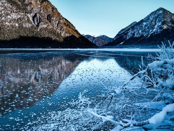 Ice crystals on a frozen lake at heiterwang, tyrol, austria against mountains