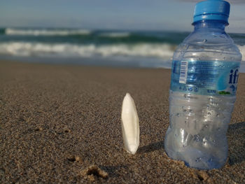 Close-up of water bottle on beach