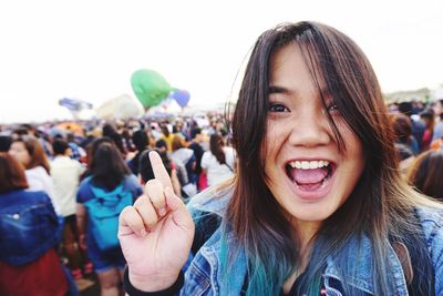 Portrait of cheerful woman gesturing while standing at event