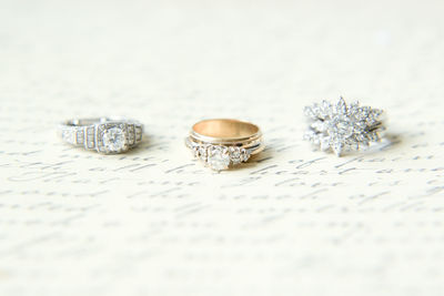 Close-up of wedding rings on white paper with text