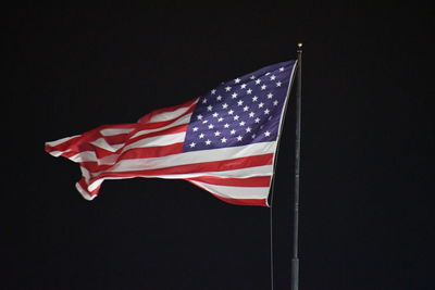 Low angle view of flag against black background