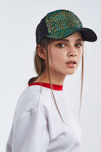 Portrait of woman wearing hat against white background