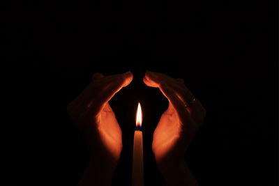 Close-up of human hand against black background