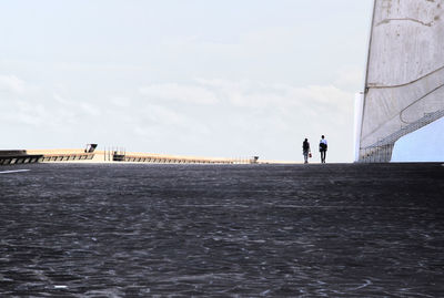 People at sea against cloudy sky