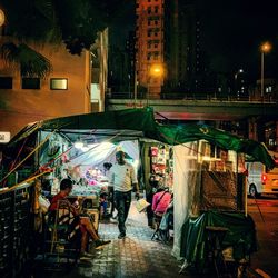 People walking on street in city at night