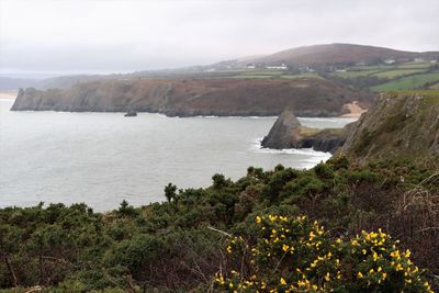 Scenic view of sea and mountains against sky