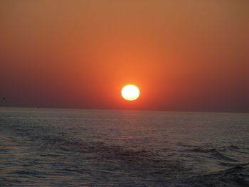 Scenic view of sea against orange sky