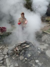 Woman standing by hot spring 