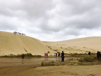 People at beach against sky