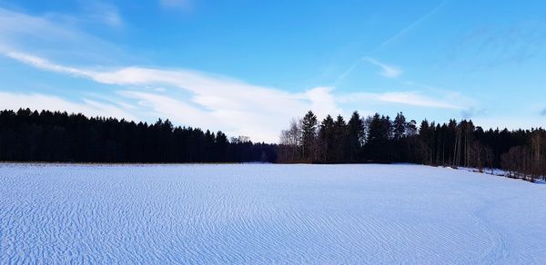 Scenic view of snow covered land against sky