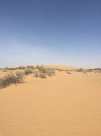 Scenic view of desert against clear blue sky