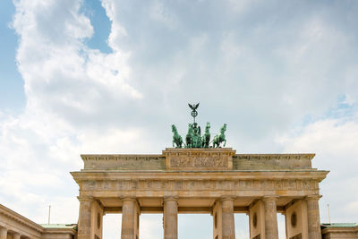 Low angle view of quadriga statue on brandenburg gate against sky