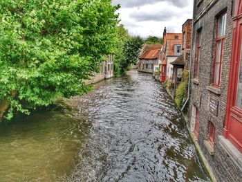 River amidst houses against sky