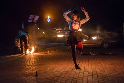 Full length of woman standing on street at night