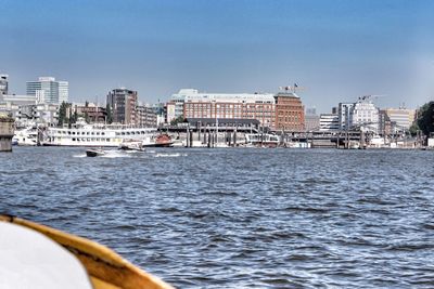 Sea by city against sky