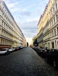 Cars on street in city against sky
