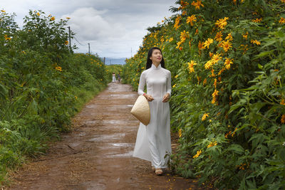 Portrait of woman walking on footpath