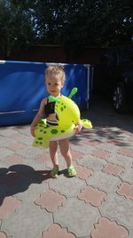 Girl standing with inflatable ring on footpath