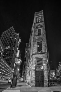 Low angle view of illuminated buildings against sky at night