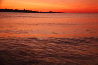 Scenic view of sea against orange sky