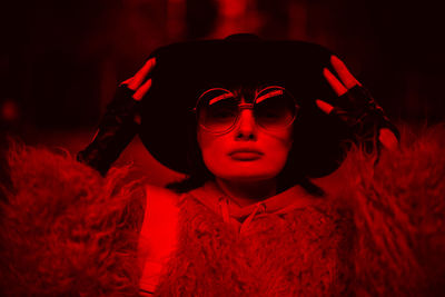 Close-up portrait of young woman wearing hat and sunglasses