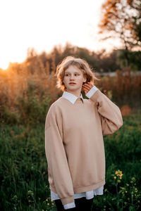 Portrait of young woman standing on field