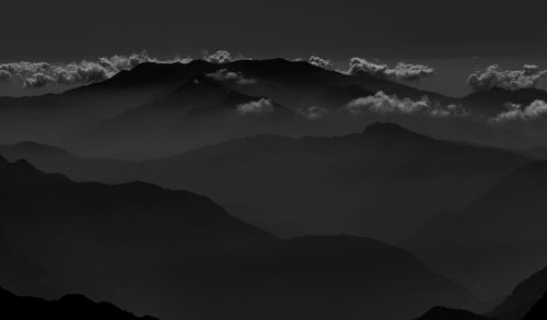Scenic view of silhouette mountains against sky at dusk
