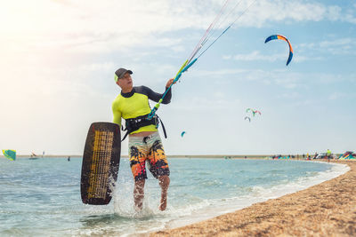 People playing in sea against sky