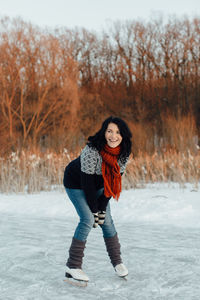 Woman in warm clothing standing on snow